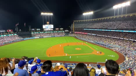 Inside-Dodger-baseball-stadium-Los-Angeles-California-Home-crowd-fans-watching-game-at-night-slow-panning-shot