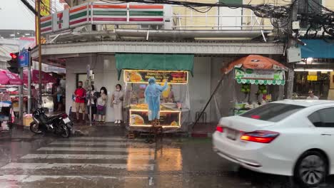 Person-Mit-Regenmantel-Schützt-Den-Straßenstand-Vor-Dem-Starken-Regen-In-Chinatown