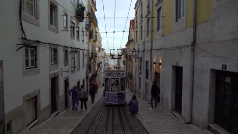 Die-Mit-Graffiti-Bemalte,-Umgebaute-Straßenbahn-Sitzt-In-Einer-Engen-Straße-Von-Lissabon