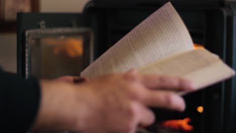 A-guy-reading-a-book-in-front-of-the-fire-place