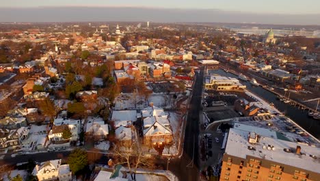 Aerial-wide-shot-of-historic-Annapolis-during-a-golden-sunrise-with-the-state-capital-building-and-US-Naval-Academy,-and-Seven-River-bridge