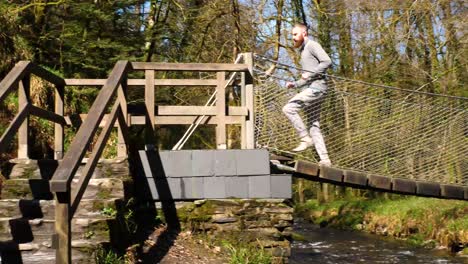 Man-running-along-and-off-a-low-hanging-bridge