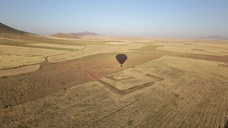 Ein-Schatten-Eines-Heißluftballons-Mit-Blick-Auf-Die-Landschaft