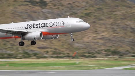 Commercial-plane-landing-at-Queenstown-Airport,-New-Zealand-with-mountains-in-background
