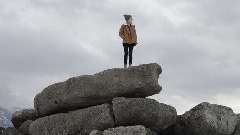 A-girl-stands-on-boulders-and-enjoys-the-view