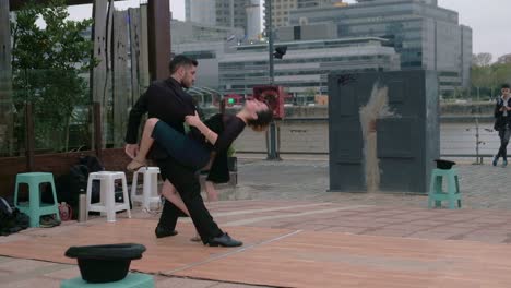 FOLLOW-MEDIUM-SHOT-Skilled-tango-street-dancers-dancing-for-tip-on-Puerto-Madero