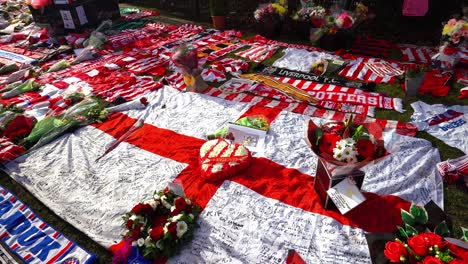 People-pay-their-respects-at-the-Gordon-Banks-statue-by-the-Stoke-City-stadium,-people-signing-shirts,-scarves,-flags-and-the-book-of-remembrance