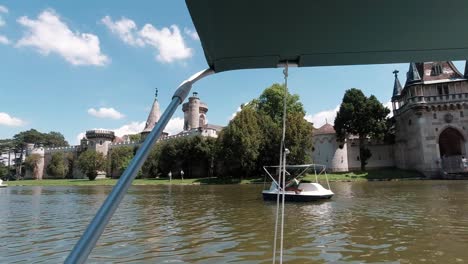 POV-view-from-boat-floating-on-lake-next-to-castle-in-Laxenburg,-near-Vienna,-Austria-SLOW-MOTION