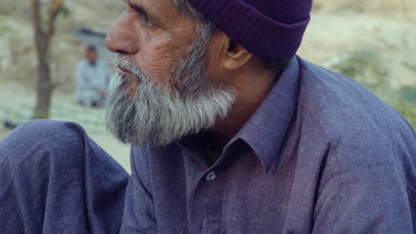 Quetta,-Pakistan,-An-old-man-with-white-beard-having-bite-of-bread,-sitting-outside,-close-up-view