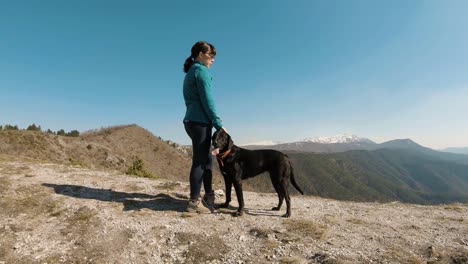 Niña-Caricias-Con-Perro-Labrador-Negro-En-Una-Montaña-En-Un-Soleado-Día-De-Otoño