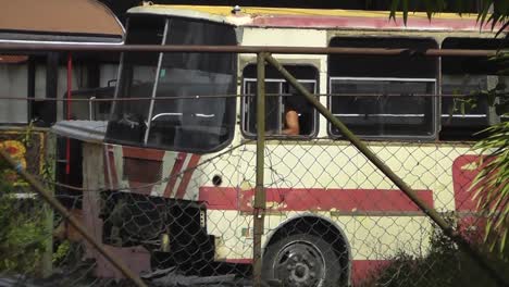 Ein-Kubanischer-Busfahrer-Fährt-Mit-Einem-Typischen-Alten-Bus-Rückwärts,-Der-Rostig-Und-Kaputt-Aussieht,-Aber-Immer-Noch-Als-Transportfahrzeug-Genutzt-Wird
