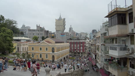 View-of-Macau-streets-and-cityscape-with-hotel-Grand-Lisboa-in-the-background-with-numerous-tourists-walking-and-taking-pictures-on-the-stairs-near-Ruins-of-St