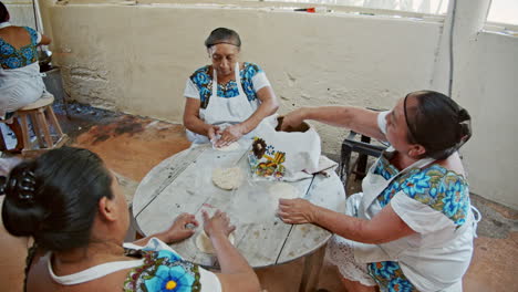Wide-slow-motion-shot-of-three-local-women-preparing-tortillias-in-the-back-of-the-kitchen