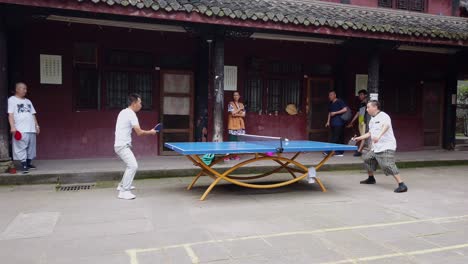 Chengdu,-China---Julio-De-2019:-Hombre-Y-Mujer-Jugando-Al-Ping-pong-En-El-Patio-Del-Monasterio-De-Wenshu-En-Chengdu,-Provincia-De-Sichuan