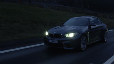Ein-Wunderschönes-Auto-Der-BMW-M2-Serie-Auf-Einer-Abendlichen-Kreuzfahrt-Auf-Der-Autobahn-Von-Nannestad,-Norwegen-–-Bewegende-Aufnahme
