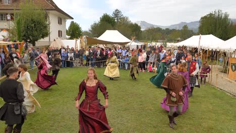 Felices-Bailarines-Disfrazados-Medievales-En-El-Evento-Medieval-Suizo,-Tiro-Ancho-Constante