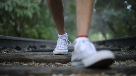 Slow-Motion-Shot-of-someone-walking-onAdandoned-Train-Tracks-towards-the-camera