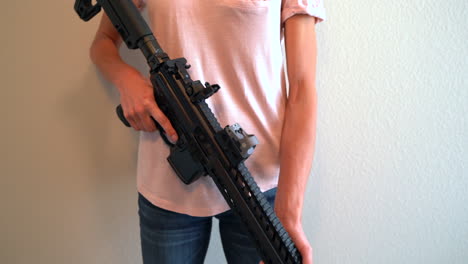 Woman-holding-a-black-assault-rifle-and-adjusting-her-grip