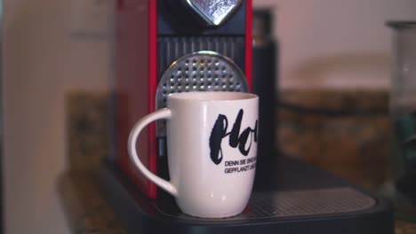 Eine-Extreme-Nahaufnahme-Von-Espresso,-Der-Aus-Einer-Maschine-In-Eine-Tasse-Tropft