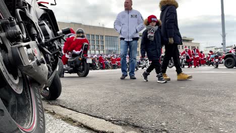 Close-up-on-brake-and-motor-wheel,-Motorcyclists-dressed-as-Santa-Clauses-during-a-charity-motorcycle-ride-through-the-city