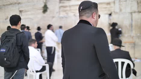 Track-shot-of-Jewish-man-walking-towards-Western-Wall,-Jerusalem