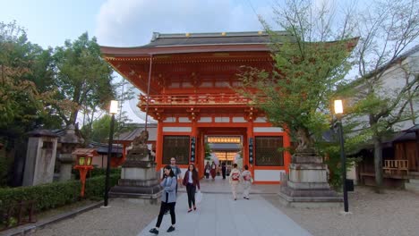 Tourists-walk-in-front-of-famous-and-iconic-shrine,-Yasaka-Shrine,-Kyoto