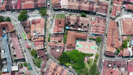 Wide-aerial-view-of-Kampung-Kolam-avenue-area-with-homes-and-buildings-along-the-route,-drone-pan-right-shot