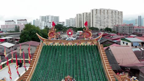 Roof-details-with-double-dragons-and-flame-orb-on-Kuan-Yin-Floating-Buddhist-Temple-in-the-Jetty-Clan-area-of-the-city,-Aerial-dolly-out-shot