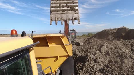 Action-cam-view-of-a-dumper-truck-being-loaded-with-earth-on-a-large-construction-site