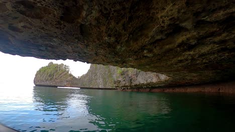 driving-under-a-limestone-island-with-a-small-boat