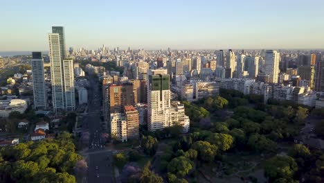 Luftaufnahme-Des-Wunderschönen-Stadtbildes-Von-Buenos-Aires,-Das-Bei-Sonnenuntergang-über-Bosques-De-Palermo-Fliegt