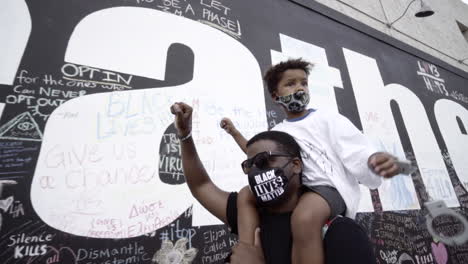 Afroamerikanischer-Vater-Mit-Seinem-Sohn-Auf-Seinen-Schultern-Bei-Einem-Protest-Gegen-Black-Lives-Matter
