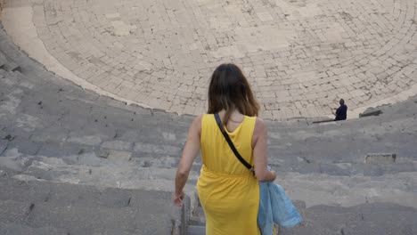 A-lady-in-yellow-walking-down-in-slow-motion-tilting-shot