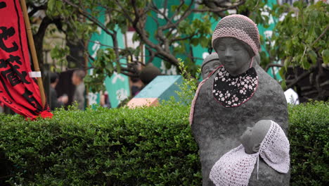 Bo-shi-Jizo-statue-of-a-mother-with-her-children-in-Senso-ji-Temple,-Tokyo