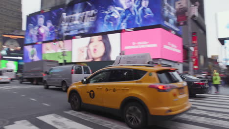 Toma-Panorámica-Siguiendo-Un-Taxi-De-Nueva-York-Mientras-Conduce-A-Través-De-Times-Square-En-Midtown-Manhattan