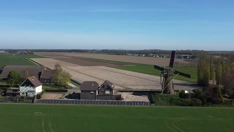 Flying-with-a-drone-past-a-rotating-Dutch-windmill-with-sails-on-the-fencing-of-the-blades