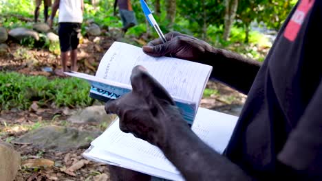 Man-Working-Outside-With-A-Receipt-Book-in-Bougainville,-Papua-New-Guinea