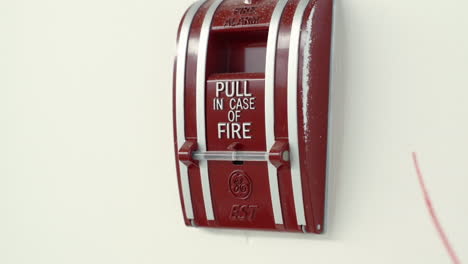 Pull-in-case-of-fire-alarm-mounted-on-white-wall