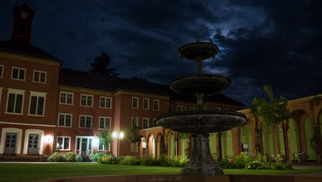 Time-Lapse-Shot-of-Old-German-Psychiatry-at-Night-with-Fountain-in-Foreground