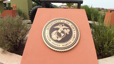 Ziehen-Sie-Sich-Vom-Bronzeemblem-Des-Marine-Corps-Zurück,-Um-Die-155-mm-Haubitzekanone-Am-Veteranendenkmal,-Fountain-Park,-Fountain-Hills,-Arizona,-Zum-Vorschein-Zu-Bringen