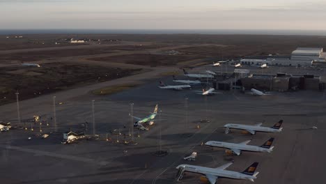 Beautiful-aerial-over-tarmac-of-Keflavik-airport-with-unused-airplanes-at-dusk