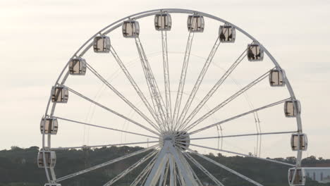 White-Spinning-Ferris-Wheel-Against-A-Cloudy-Sky---medium-shot