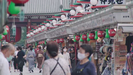 Rows-Of-Stores-And-Crowd-Of-People-With-Protective-Masks-At-The-Nakamise-Shopping-Street-In-Asakusa,-Tokyo,-Japan-During-Covid-19-Pandemic---close-up