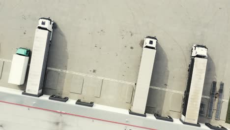 Aerial-view-of-the-logistics-warehouse-with-trucks-waiting-for-loading