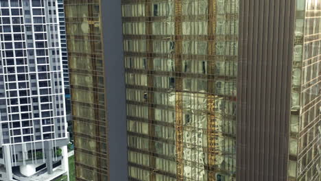 Rising-Aerial-Shot-Of-Ibis-Hotel-In-Kuala-Lumpur,-Reflections-In-Glass-Windows-Of-Skyscraper