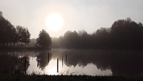 Lake-in-ethereal-early-morning-light-with-low-hanging-misty-clouds
