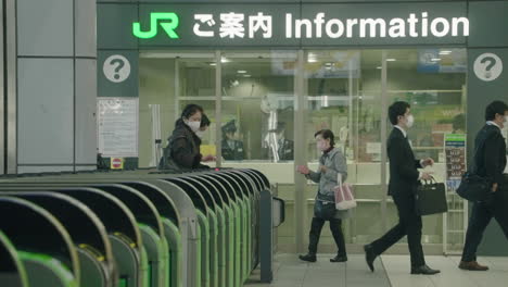 Pocas-Personas-Con-Máscaras-Ingresan-A-Las-Puertas-De-Boletos-En-La-Estación-Shinagawa-Jr-Durante-La-Pandemia-En-Tokio,-Japón---Cámara-Lenta
