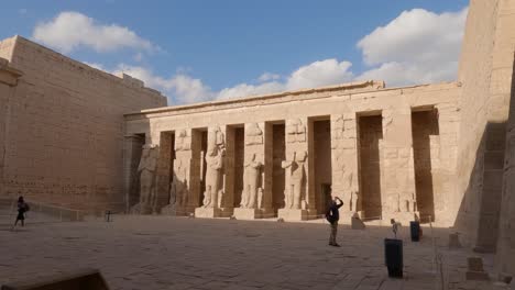 Antiguas-Estatuas-Egipcias-En-El-Primer-Patio-Del-Templo-De-Ramsés-Iii-En-Medinet-Habu,-Egipto