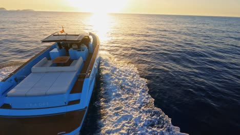 Picturesque-FPV-aerial-circling-a-luxury-yacht-sailing-into-the-sunset-off-the-coast-of-Ibiza