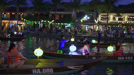 Touristen-Unternehmen-Eine-Laternenbootfahrt-Auf-Dem-Hoai-Fluss-In-Sampan-Booten-In-Der-Antiken-Stadt-Hoi-An-Während-Des-Lichtfestivals-In-Der-Nacht,-Vietnam